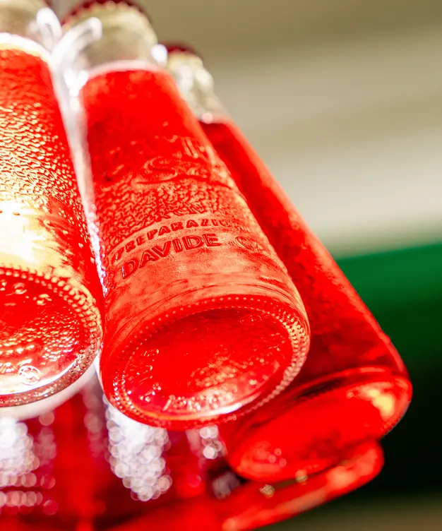 Suspension en bouteilles de Campari Soda rouges au-dessus du bar
