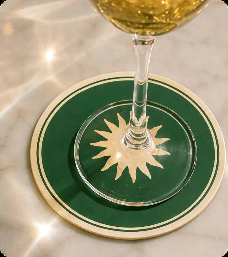 Dessous de verre Scopertino vert et or sous un verre de vin blanc