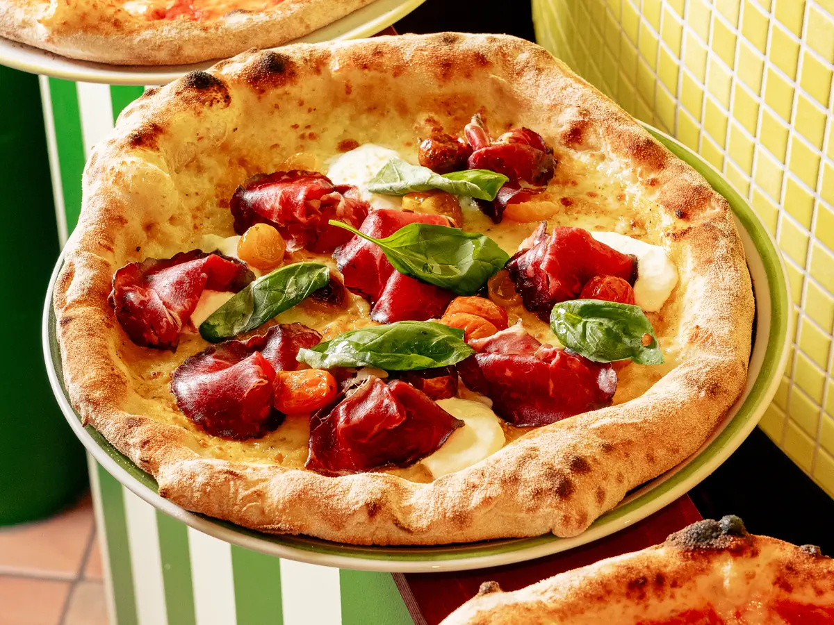 Pizza napolitaine à la bresaola, tomates confites et basilic, bords soufflés au four
