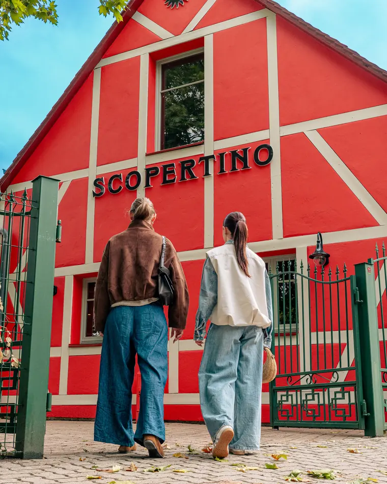Deux amies passent le portail de la maison Scopertino en plein jour