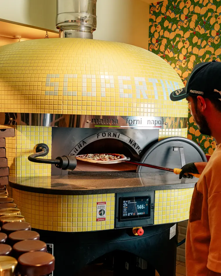 Le four à pizza napolitain en mosaïque jaune siglé Scopertino, une pizza à l'intérieur
